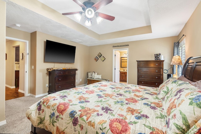 1002 S Joshua Ave, Republic, MO 65738 - carpeted bedroom featuring baseboards, a raised ceiling, ceiling fan, and connected bathroom