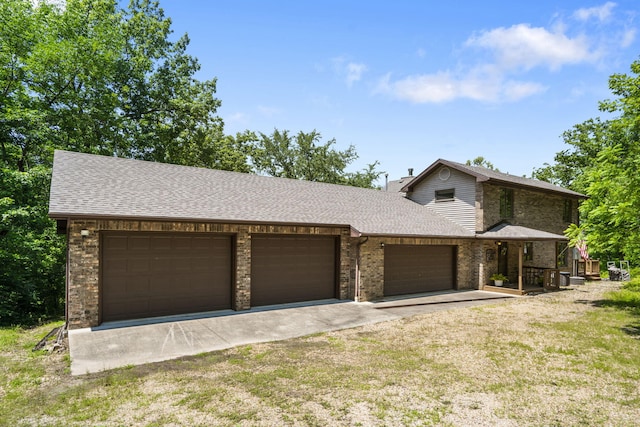 26517 Farm Rd Unit 1212, Eagle Rock, MO 65641 - view of front of house featuring an attached garage, driveway, roof with shingles, brick siding, and a front lawn