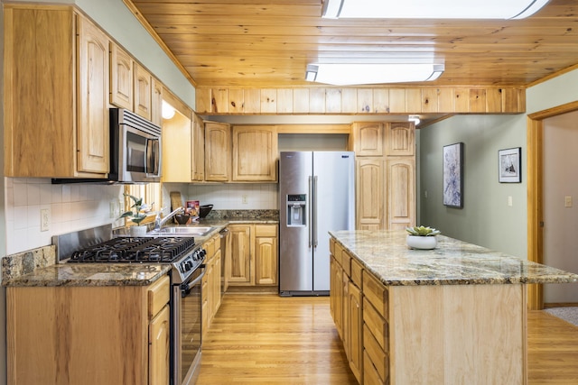 26517 Farm Rd Unit 1212, Eagle Rock, MO 65641 - kitchen with appliances with stainless steel finishes, light wood-style floors, dark stone countertops, tasteful backsplash, and a kitchen island