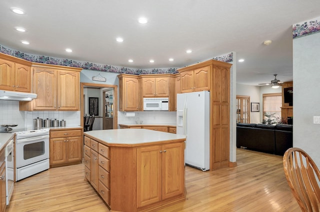 2411 W Dearborn St, Springfield, MO 65807 - kitchen featuring white appliances, a kitchen island, under cabinet range hood, light wood finished floors, and recessed lighting