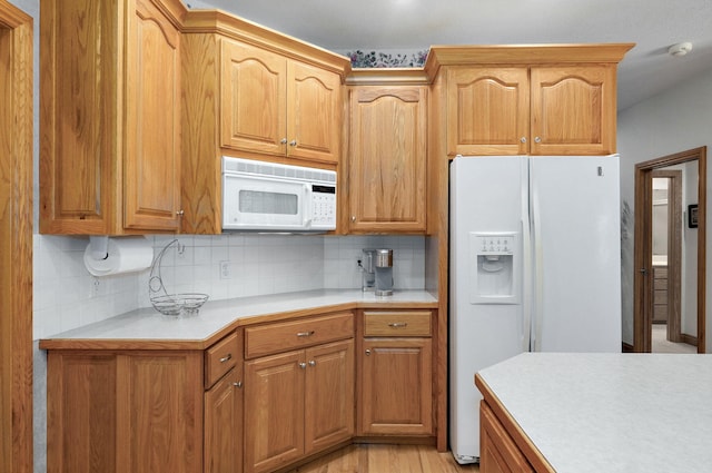 2411 W Dearborn St, Springfield, MO 65807 - kitchen featuring white appliances, light countertops, backsplash, light wood finished floors, and brown cabinetry