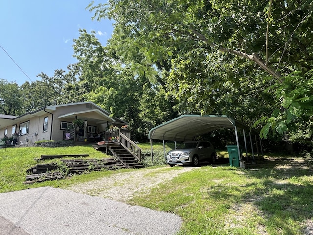 720 Highland St, Cabool, MO 65689 - view of front facade featuring a front yard, driveway, a carport, covered porch, and stucco siding