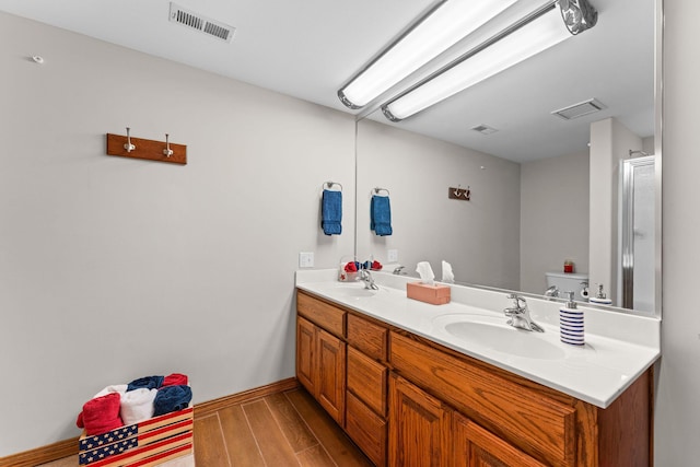 159 Oak Tree Point Ln, Shell Knob, MO 65747 - bathroom featuring wood finished floors, double vanity, baseboards, and toilet