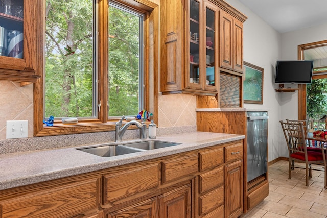 159 Oak Tree Point Ln, Shell Knob, MO 65747 - kitchen with brown cabinetry, a sink, tasteful backsplash, glass insert cabinets, and light tile patterned floors