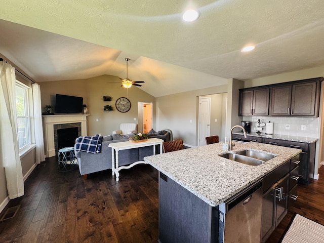 607 E Selby Dr, Nixa, MO 65714 - kitchen featuring stainless steel dishwasher, open floor plan, dark wood-style flooring, light stone countertops, and lofted ceiling