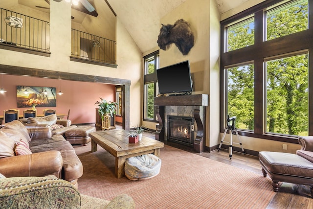1029 Riverview Rd, Clever, MO 65631 - living area with high vaulted ceiling, a glass covered fireplace, wood-type flooring, and ceiling fan