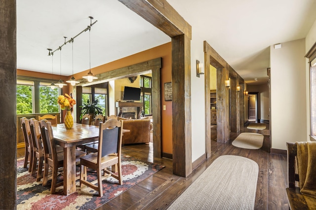 1029 Riverview Rd, Clever, MO 65631 - dining area with rail lighting, hardwood / wood-style flooring, and a warm lit fireplace