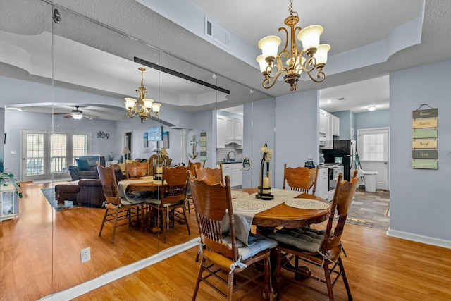 310 Woodland Dr Unit Lb, Branson, MO 65616 - dining space featuring a chandelier, a tray ceiling, ceiling fan, and light wood-style floors