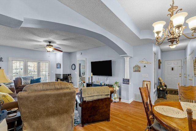 310 Woodland Dr Unit Lb, Branson, MO 65616 - living room with arched walkways, a textured ceiling, ornate columns, a ceiling fan, and light wood-type flooring