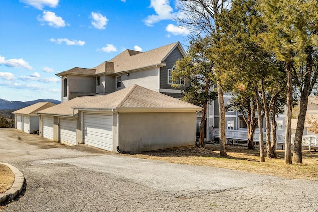 310 Woodland Dr Unit Lb, Branson, MO 65616 - view of home's exterior featuring a shingled roof, driveway, and stucco siding