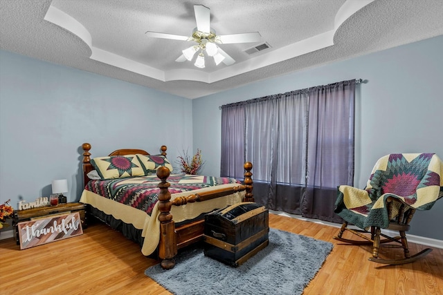 310 Woodland Dr Unit Lb, Branson, MO 65616 - bedroom with a textured ceiling, a tray ceiling, wood finished floors, and a ceiling fan