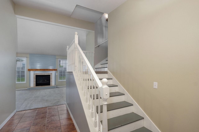 713 River Rock Ct, Nixa, MO 65714 - staircase featuring a fireplace with raised hearth and carpet flooring