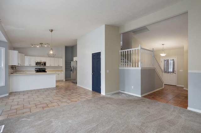 713 River Rock Ct, Nixa, MO 65714 - kitchen with stainless steel appliances, lofted ceiling, white cabinets, light countertops, and a peninsula