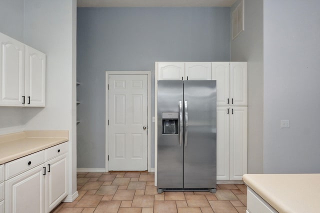 713 River Rock Ct, Nixa, MO 65714 - kitchen with stainless steel refrigerator with ice dispenser, white cabinetry, and light countertops