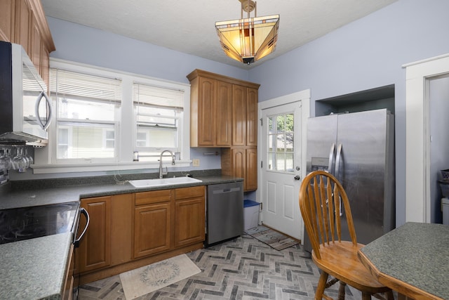 817 W Walnut St, Springfield, MO 65806 - kitchen with appliances with stainless steel finishes, brown cabinets, dark countertops, and hanging light fixtures