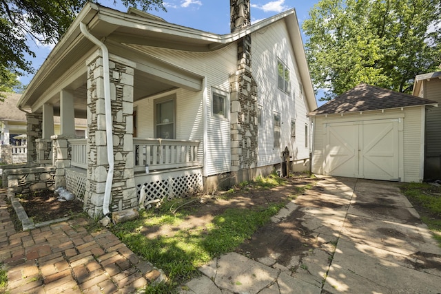 817 W Walnut St, Springfield, MO 65806 - view of property exterior featuring a porch, an outdoor structure, driveway, a detached garage, and a chimney