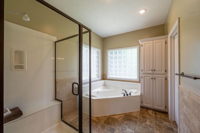 4910 S Stanton Ave, Springfield, MO 65810 - bathroom with a bath, a shower stall, a wainscoted wall, recessed lighting, and tile walls