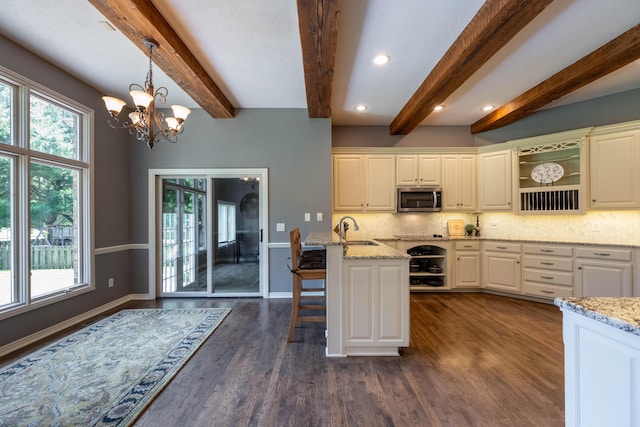 4910 S Stanton Ave, Springfield, MO 65810 - kitchen with stainless steel microwave, healthy amount of natural light, open shelves, beam ceiling, and recessed lighting