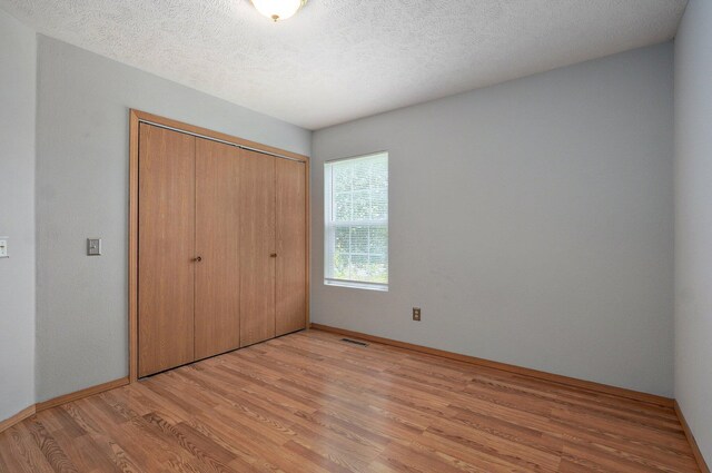 1651 S Mahn Ct, Springfield, MO 65802 - unfurnished bedroom with light wood-type flooring, a closet, and a textured ceiling