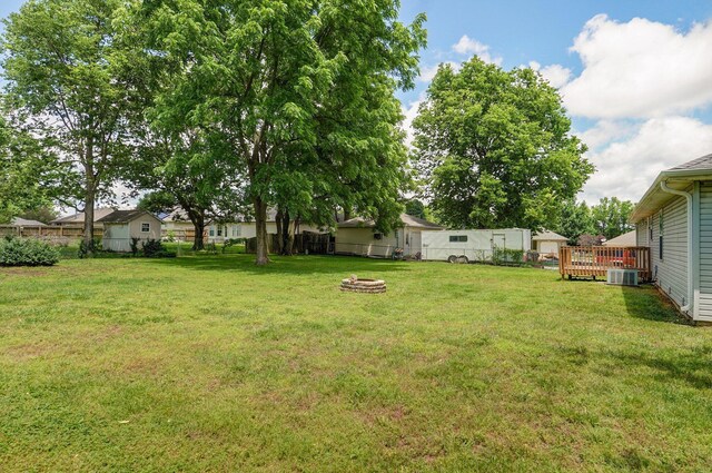 1651 S Mahn Ct, Springfield, MO 65802 - fenced backyard featuring a wooden deck and a fire pit