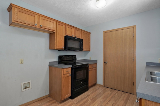 1651 S Mahn Ct, Springfield, MO 65802 - kitchen with black appliances, light wood-type flooring, brown cabinets, dark countertops, and a textured ceiling
