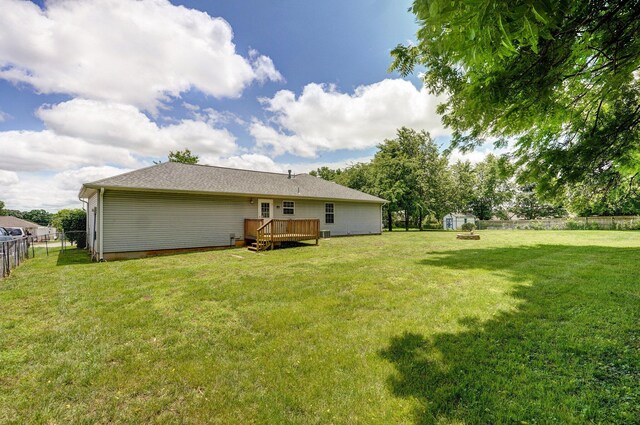 1651 S Mahn Ct, Springfield, MO 65802 - back of property with a fenced backyard, a deck, and a storage shed