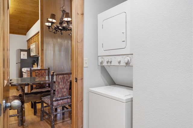 76 Bells Ave Unit 98, Branson West, MO 65737 - laundry area featuring stacked washer / dryer, a chandelier, a textured wall, wood finished floors, and wooden ceiling