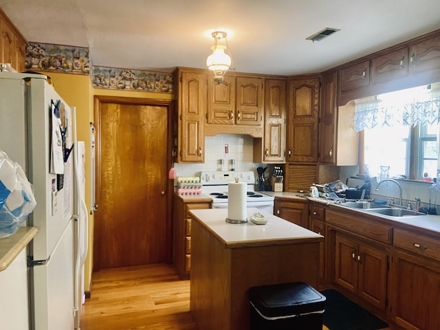 513 Meng St, Greenfield, MO 65661 - kitchen featuring white appliances, light countertops, decorative backsplash, light wood-type flooring, and brown cabinets