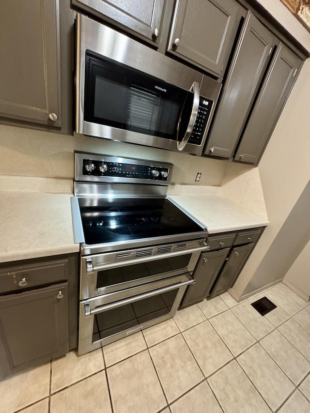 701 Barracuda Dr, Nixa, MO 65714 - kitchen featuring stainless steel appliances, light tile patterned floors, gray cabinets, and light countertops