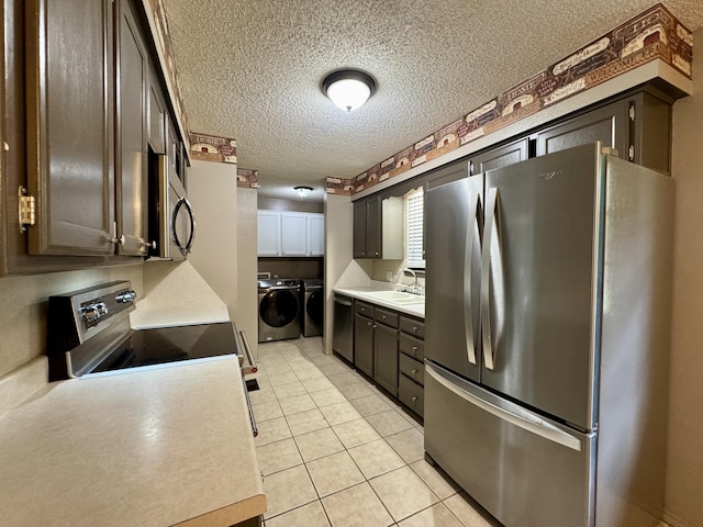 701 Barracuda Dr, Nixa, MO 65714 - kitchen featuring stainless steel appliances, separate washer and dryer, a textured ceiling, light countertops, and light tile patterned floors