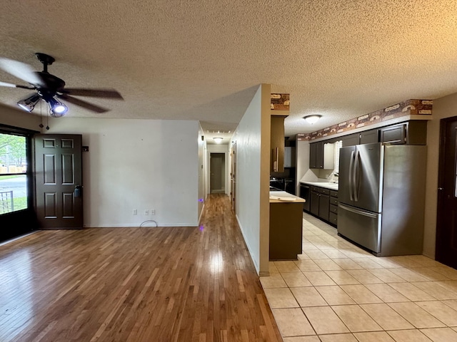 701 Barracuda Dr, Nixa, MO 65714 - kitchen with freestanding refrigerator, light countertops, light wood finished floors, a ceiling fan, and a textured ceiling