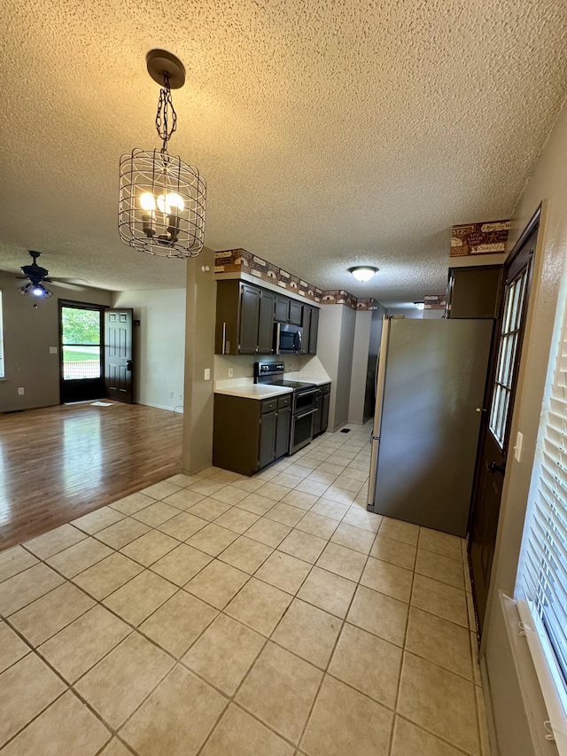 701 Barracuda Dr, Nixa, MO 65714 - kitchen featuring appliances with stainless steel finishes, a textured ceiling, a ceiling fan, light tile patterned floors, and light countertops