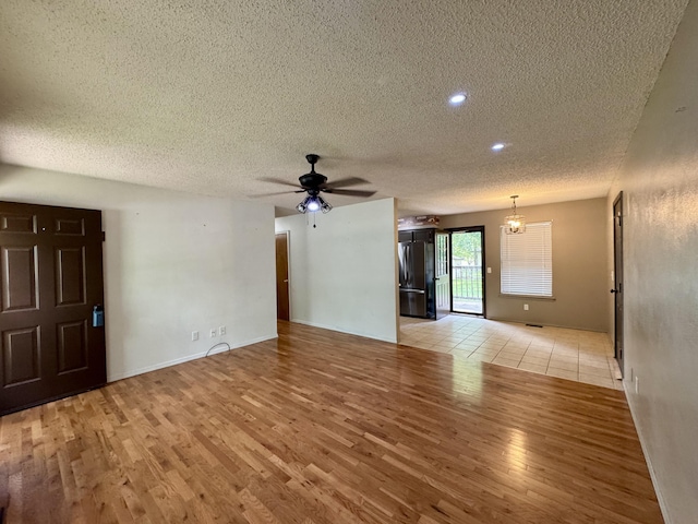 701 Barracuda Dr, Nixa, MO 65714 - unfurnished living room featuring a textured ceiling, light wood-type flooring, a ceiling fan, and recessed lighting