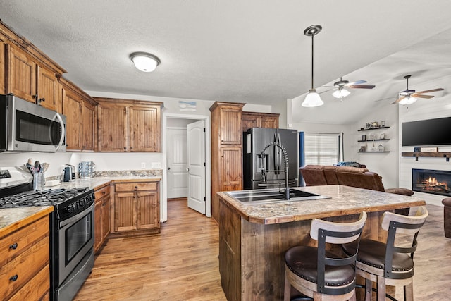 208 Dixie Ave, Clever, MO 65631 - kitchen with appliances with stainless steel finishes, open floor plan, light wood-type flooring, an island with sink, and vaulted ceiling