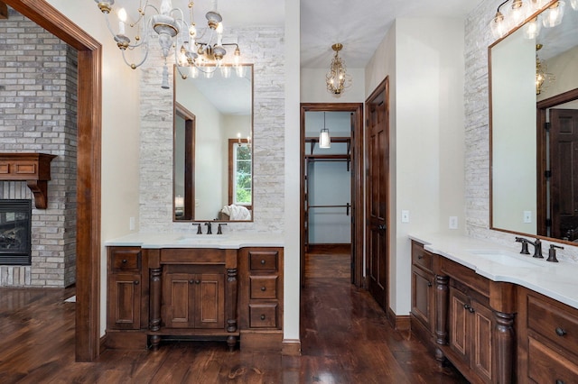 7607 N Angler Ln, Strafford, MO 65757 - full bath featuring a chandelier, hardwood / wood-style floors, two vanities, and a brick fireplace