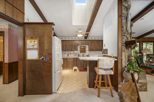 26307 Twin Rivers Dr, Shell Knob, MO 65747 - kitchen featuring white refrigerator with ice dispenser, light countertops, a breakfast bar area, light flooring, and a ceiling fan