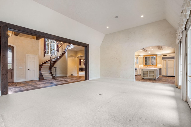 4156 E Division St, Springfield, MO 65802 - unfurnished living room featuring arched walkways, high vaulted ceiling, recessed lighting, plenty of natural light, and stairs