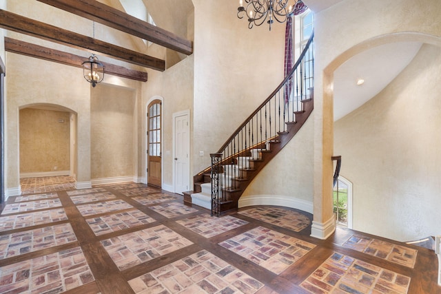 4156 E Division St, Springfield, MO 65802 - foyer featuring arched walkways, a chandelier, a towering ceiling, brick patterned floors, and stairs
