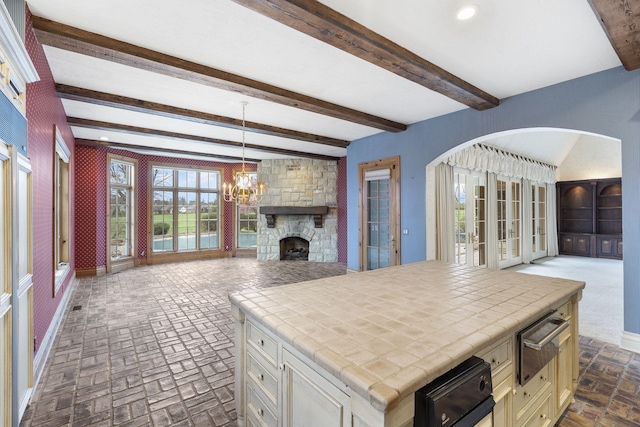 4156 E Division St, Springfield, MO 65802 - kitchen with tile counters, open floor plan, a warming drawer, brick floors, and beam ceiling