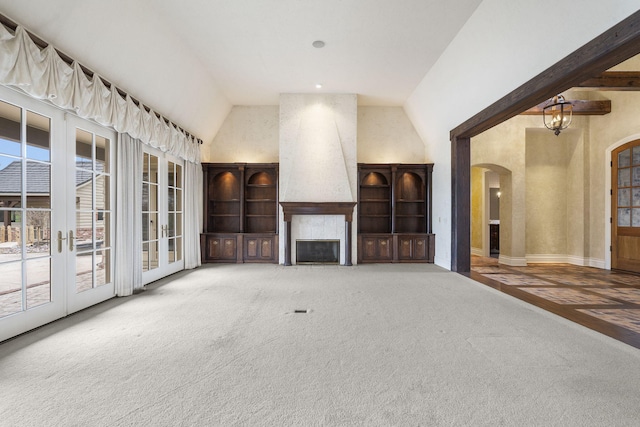 4156 E Division St, Springfield, MO 65802 - unfurnished living room featuring arched walkways, a fireplace, carpet flooring, and high vaulted ceiling