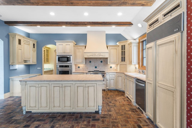 4156 E Division St, Springfield, MO 65802 - kitchen featuring cream cabinets, built in appliances, custom range hood, light countertops, and backsplash