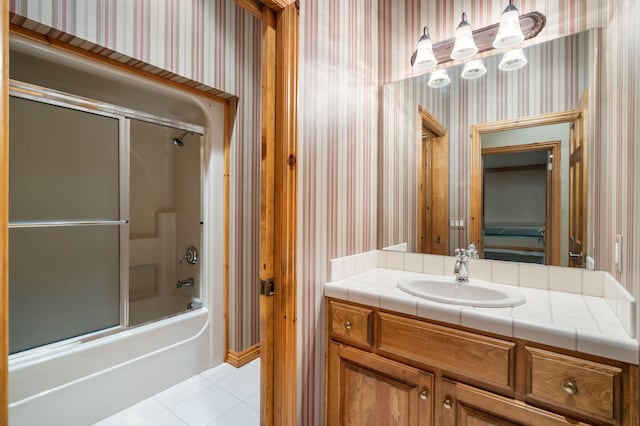 4156 E Division St, Springfield, MO 65802 - full bath with wallpapered walls, vanity, tile patterned floors, and bath / shower combo with glass door
