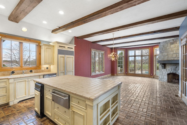 4156 E Division St, Springfield, MO 65802 - kitchen featuring tile counters, a warming drawer, cream cabinetry, beamed ceiling, and recessed lighting