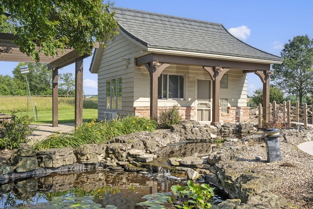 4156 E Division St, Springfield, MO 65802 - view of side of property with brick siding, a pergola, and a garden pond