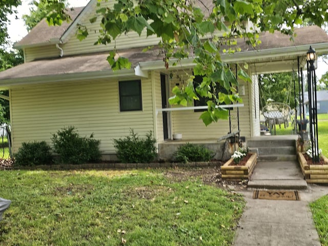 312 W Locust St, Aurora, MO 65605 - rear view of house with roof with shingles and a lawn