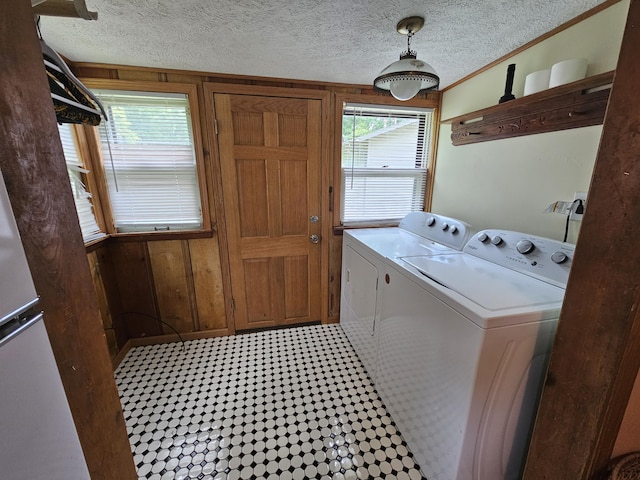 312 W Locust St, Aurora, MO 65605 - washroom with washer and clothes dryer, healthy amount of natural light, a textured ceiling, and wooden walls