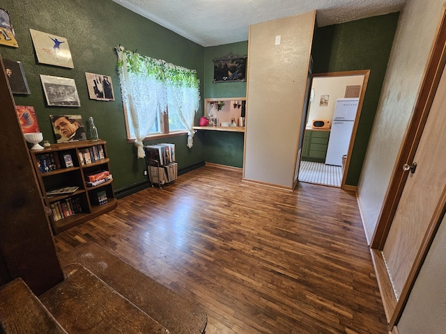 312 W Locust St, Aurora, MO 65605 - bedroom featuring refrigerator, hardwood / wood-style floors, a textured ceiling, and a textured wall