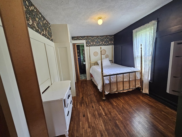 312 W Locust St, Aurora, MO 65605 - bedroom featuring dark wood-style flooring, a decorative wall, a textured ceiling, and wainscoting