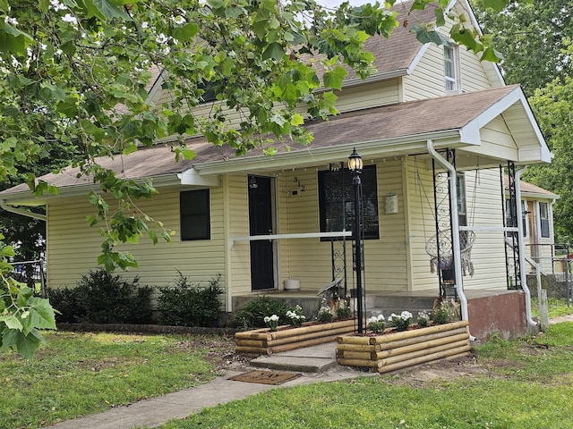 312 W Locust St, Aurora, MO 65605 - view of front of home featuring a shingled roof, covered porch, and a front lawn