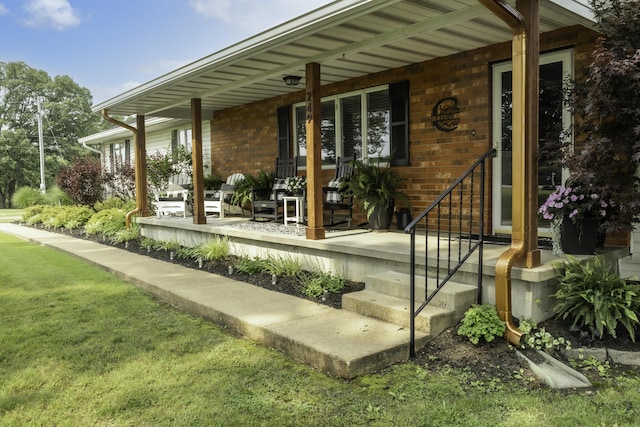 249 State Highway 73, Macks Creek, MO 65786 - doorway to property with covered porch, brick siding, and a lawn